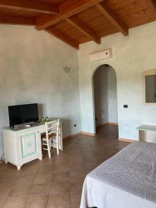 a bedroom with a bed and a desk with a television at Agriturismo San Giovanni in Olbia