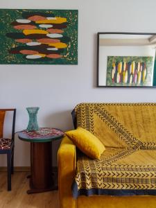 One&Only Saska Kępa Apartment في وارسو: غرفة معيشة مع أريكة صفراء وطاولة
