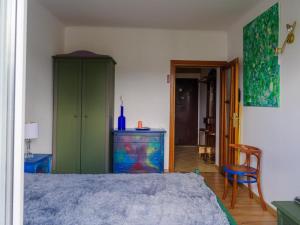 One&Only Saska Kępa Apartment في وارسو: غرفة نوم مع سرير وكابينة خضراء