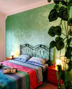 een slaapkamer met een bed met een groene muur bij Punto Verde B&B in Ardore Marina