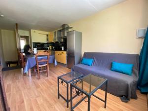 uma sala de estar com um sofá e uma mesa em La Mongie - Apt 2 ch - 8 pers - Place parking couvert em La Mongie