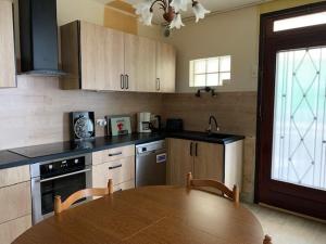 cocina con mesa de madera y comedor en Le Relax, en Saint-Aignan