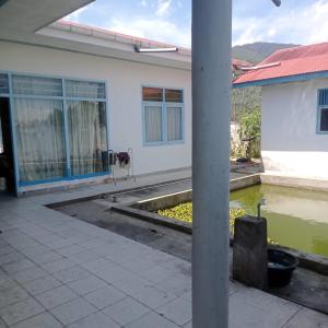 une maison avec une piscine d'eau en face de celle-ci dans l'établissement Homestay Sungai Angek, à Baso