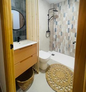 a bathroom with a sink and a toilet and a mirror at Casa del palmar suite in Valencia