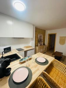 una cocina con mesa de madera y 2 placas blancas. en Casa del palmar suite, en Valencia
