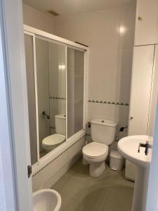 uma casa de banho branca com um WC e um lavatório em Apartamento la almadraba em Chiclana de la Frontera