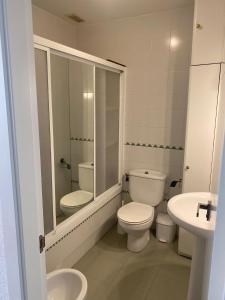 biała łazienka z toaletą i umywalką w obiekcie Apartamento la almadraba w mieście Chiclana de la Frontera