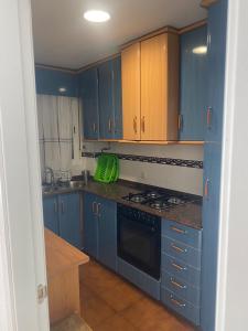 kuchnia z niebieskimi szafkami i kuchenką w obiekcie Apartamento la almadraba w mieście Chiclana de la Frontera