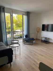 a living room with a couch and tables and a balcony at JADE, STUDIO au coeur de la ville in Villers-sur-Mer