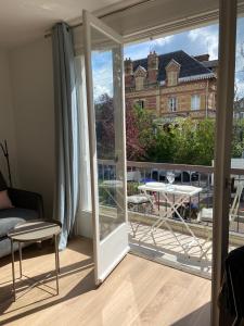 a room with a sliding glass door and a balcony at JADE, STUDIO au coeur de la ville in Villers-sur-Mer
