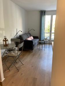 a living room with a couch and a table at JADE, STUDIO au coeur de la ville in Villers-sur-Mer