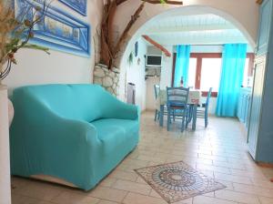 a living room with a blue couch and a table at Sardinia Yellow House in Solanas