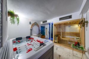 a bathroom with a tub with red flowers in it at Il Giardino Fiorentino - Luxury Apartment & Spa in Florence