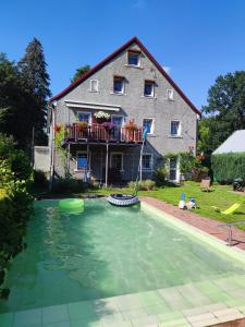 ein Haus mit einem Pool vor einem Haus in der Unterkunft Agroturystyka u Strażaka in Świeradów-Zdrój