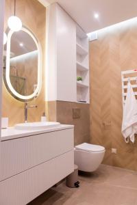 een badkamer met een toilet, een wastafel en een spiegel bij Forest 21 by Housine in Zator