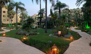 un parque con palmeras y luces por la noche en Oasis Costalita Estepona I, en Estepona