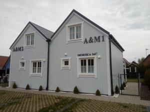 a white house with words on the side of it at A&M Apartamenty in Łukęcin