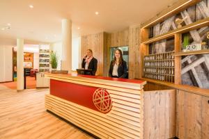 two people standing at a counter in a store lobby at Landhotel Alte Mühle in Ostrach +59 photos