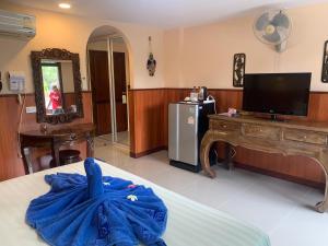 Cette chambre comprend un lit, une télévision et un bureau. dans l'établissement Laguna Beach Club Resort, à Ko Lanta