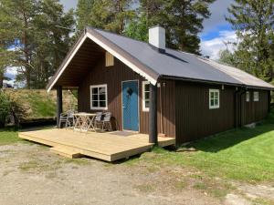 a small cabin with a porch and a deck at Roste Hyttetun og Camping in Os