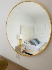 - une chambre avec un lit et un miroir rond dans l'établissement Pokoje Gościnne i Apartamenty Ula, à Ustronie Morskie