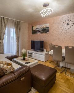 - un salon avec un canapé et une table dans l'établissement Lux Deluxe Apartment, à Žabljak