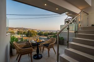 a balcony with a table and chairs and stairs at Gifel Apartments and Luxurious Suites in Kalamaki Heraklion