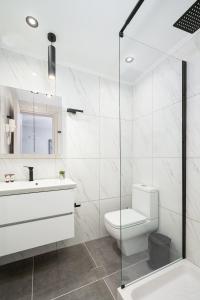 a white bathroom with a toilet and a sink at Gifel Apartments and Luxurious Suites in Kalamaki Heraklion