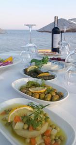 una mesa con platos de comida y copas de vino en Yilmaz Hotel, en Ortakent