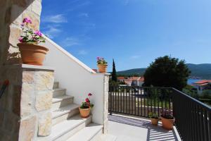 a balcony with potted plants on the stairs of a house at Apartment Pridraga in Pridraga