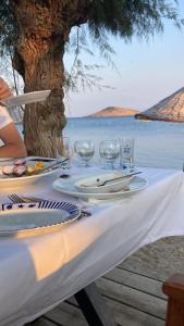 a table with plates and wine glasses on the beach at Yilmaz Hotel in Ortakent