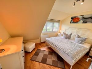 a bedroom with a bed and a sink at Ferienhaus Anna - rechte Seite in Dranske