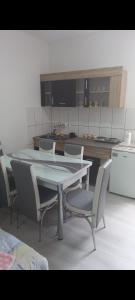 Apartman LJILJANA BELA CRKVA في بيلا تسركفا: طاولة وكراسي في مطبخ مع طاولة وكاونتر