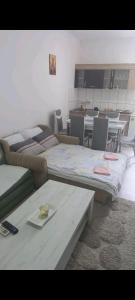 een kamer met drie bedden en een tafel erin bij Apartman LJILJANA BELA CRKVA in Bela Crkva