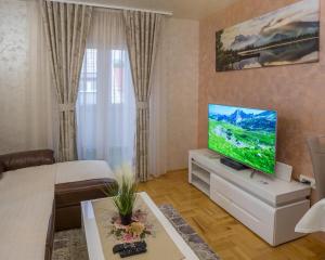 a living room with a flat screen tv on a cabinet at Lux Deluxe Apartment in Žabljak