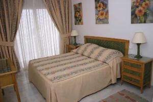 a bedroom with a bed and a table and a window at Balcones del Chaparral, Mijas Costa in Mijas Costa