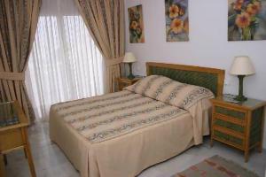sypialnia z łóżkiem, stołem i oknem w obiekcie Balcones del Chaparral, Mijas Costa w mieście Mijas Costa