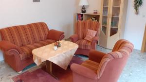 uma sala de estar com duas cadeiras e uma mesa em Familienurlaub in Ostfriesland für max 7 Pers in 2 Wohnungen, auch Einzeln Wohnungen em Utarp