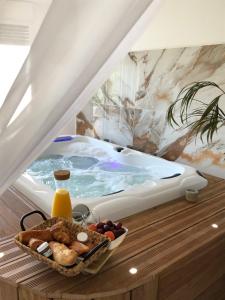 a tray of food on a table next to a bath tub at Studio La Boheme Jacuzzi et Terrasse vu sur Pic Saint Loup in Prades-le-Lez