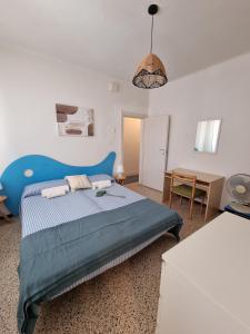 Schlafzimmer mit einem blauen Bett und einem Tisch in der Unterkunft Villa Lisa - La quiete e il profumo del mare in Grado