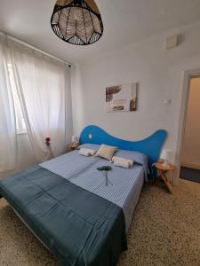 1 dormitorio con cama azul y cabecero azul en Villa Lisa - La quiete e il profumo del mare, en Grado