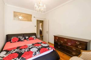una camera con un letto e un comò con rose rosse di Κεντρικό κλασικό διαμέρισμα 2 δωματίων a Salonicco