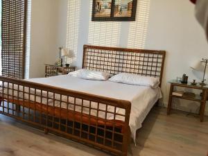 a bedroom with a large wooden bed with white sheets at Rahoni Park & Suites in Dhërmi