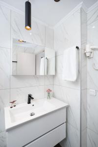 a white bathroom with a sink and a mirror at Gifel Apartments and Luxurious Suites in Kalamaki Heraklion +24 photos
