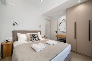 a bedroom with a large bed with two towels on it at Gifel Apartments and Luxurious Suites in Kalamaki Heraklion
