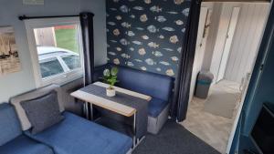 una mesa pequeña y una silla en una habitación con coche en Castaway Retreats 3 E65 en Lincolnshire