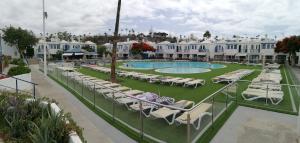 um resort com piscina e espreguiçadeiras em Villa Natura Maspalomas Complejo Playmar em Maspalomas