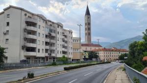 an empty street with a building and a clock tower at Memories apartment in Mostar
