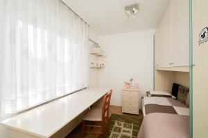 een slaapkamer met een bureau, een bed en een raam bij Family Apartment Magnolia - Free Private Parking in Ljubljana