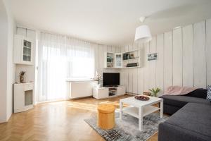 een woonkamer met een bank en een tafel bij Family Apartment Magnolia - Free Private Parking in Ljubljana